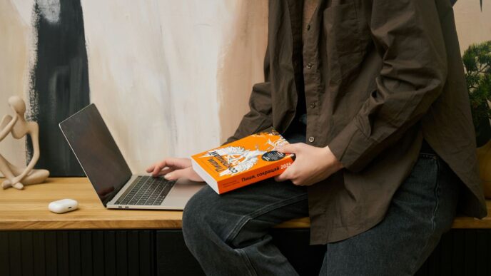 a person sitting on a table with a laptop