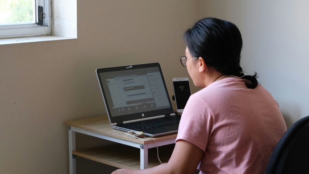 woman in pink t-shirt using laptop computer