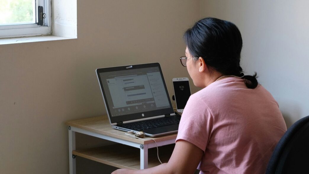 woman in pink t-shirt using laptop computer