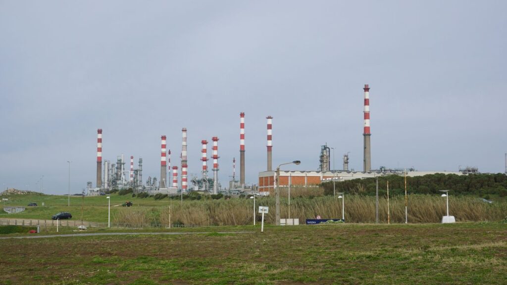 An industrial plant with chimneys and infrastructure is visible.