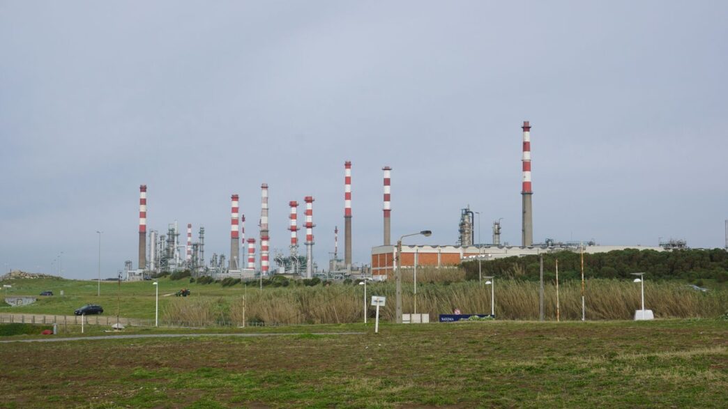 An industrial plant with chimneys and infrastructure is visible.