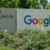 a google sign in front of some bushes and trees