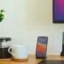 black iphone 7 beside white ceramic mug on brown wooden table