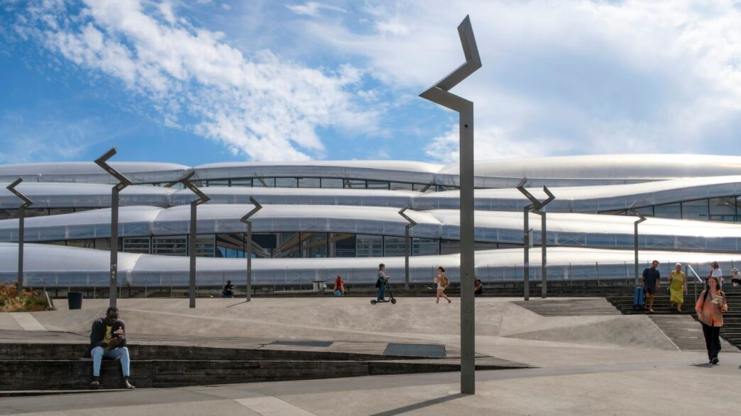Modern building with wavy facade and people outside