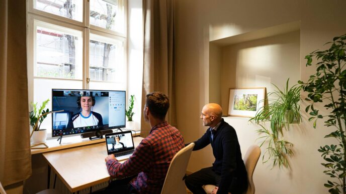 man in black long sleeve shirt sitting on chair in front of computer