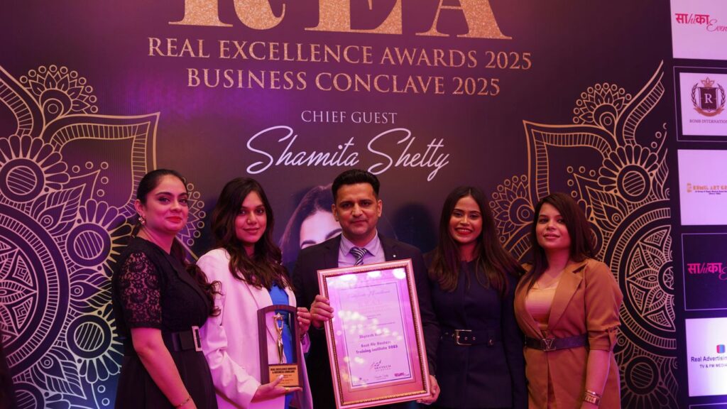 Group poses with award at real excellence awards 2025.