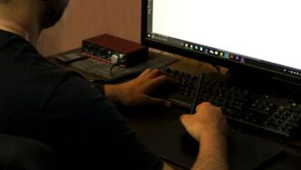 person in black long sleeve shirt using computer