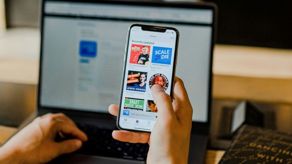 person using smartphone and laptop at the same time