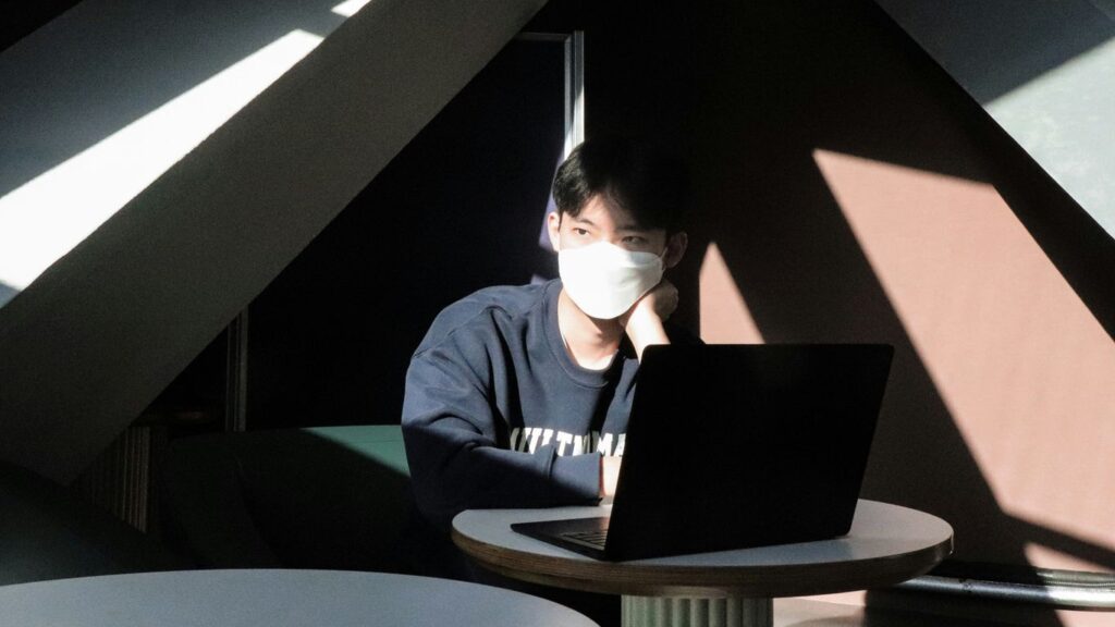 a man sitting at a table using a laptop computer