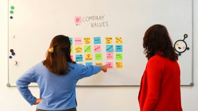a couple of women standing in front of a white board