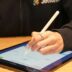 a person writing on a tablet with a pen