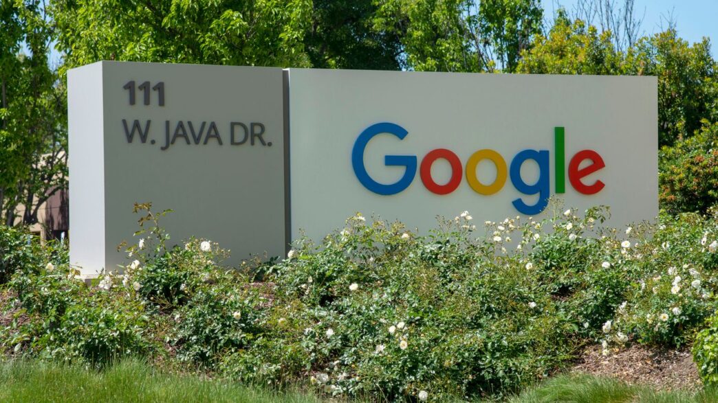 a google sign in front of some bushes and trees