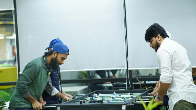 two men playing a game of foo - pong in an office