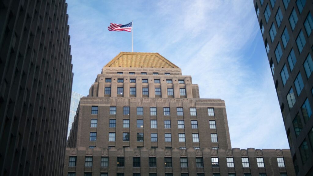 brown concrete building with flag of us a during daytime