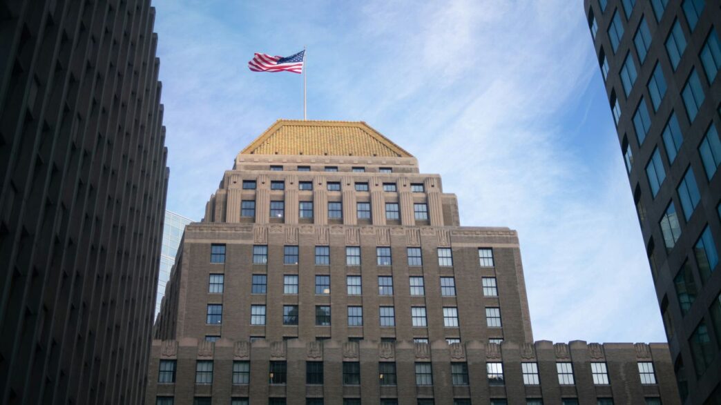 brown concrete building with flag of us a during daytime