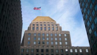 brown concrete building with flag of us a during daytime