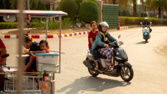 two person riding motor scooter