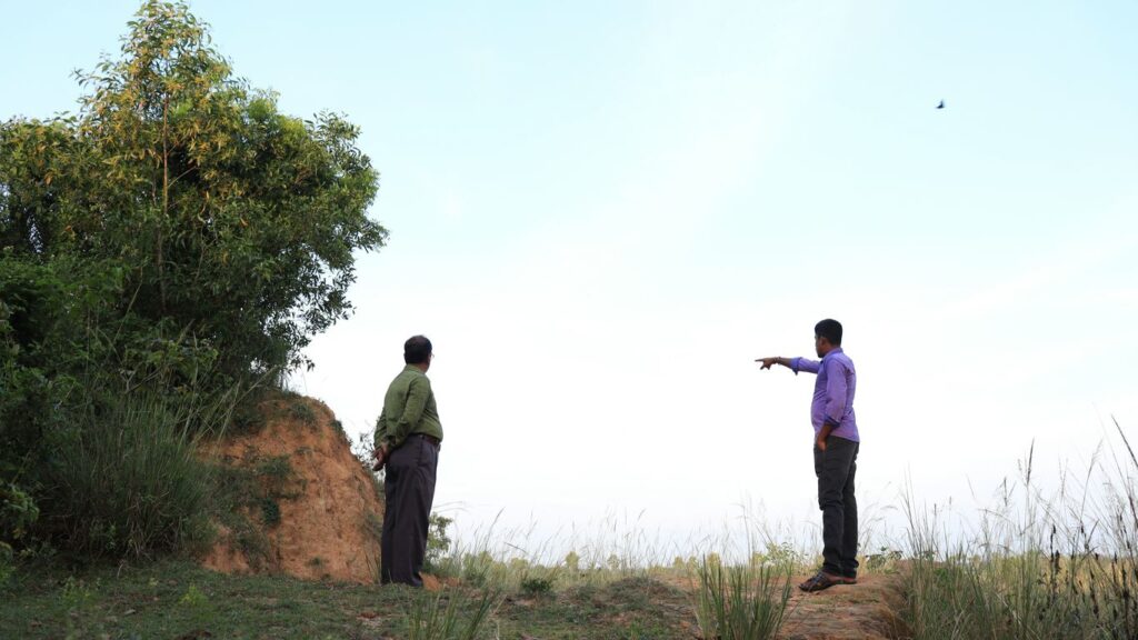 two men standing on a hill