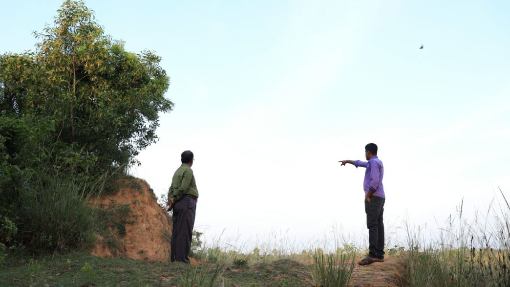 two men standing on a hill