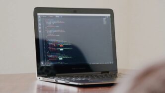 turned-on laptop with computer programming codes display