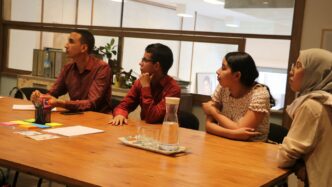 two women and men sitting at table