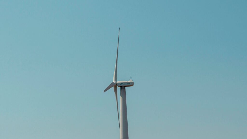 a wind turbine in the middle of a clear blue sky