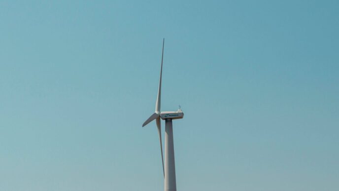 a wind turbine in the middle of a clear blue sky
