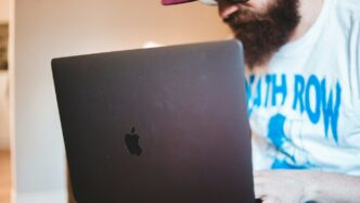 man in white shirt using black macbook
