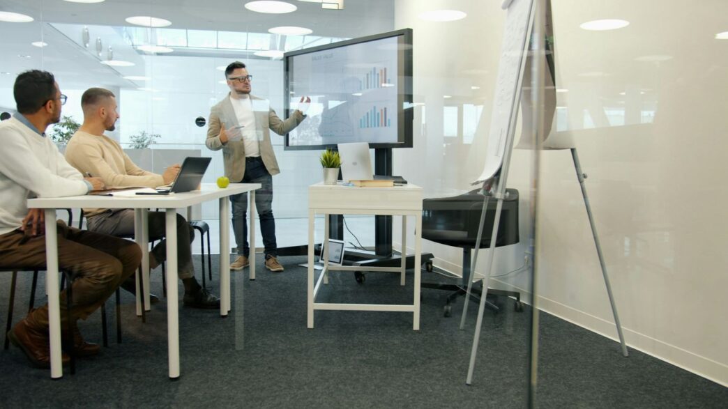 Man presenting to colleagues in a modern office.