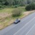 a black car driving down a road