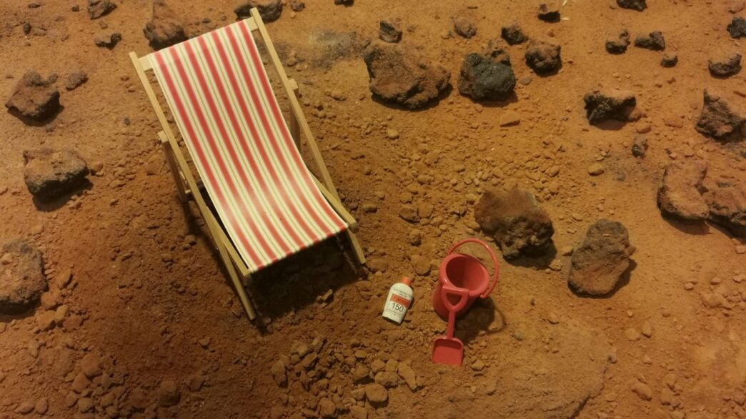 red and white striped folding bed on brown sand