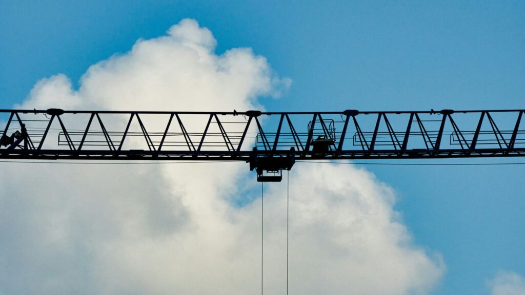 a crane flying over a bridge