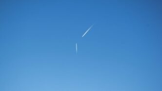 an airplane is flying high in the sky