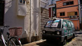 a van parked on the side of a street next to a bike