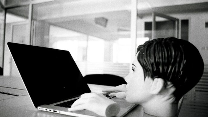 a young boy sitting in front of a laptop computer