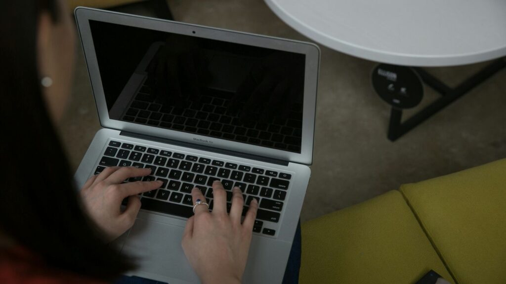 Woman typing on a laptop computer at a table