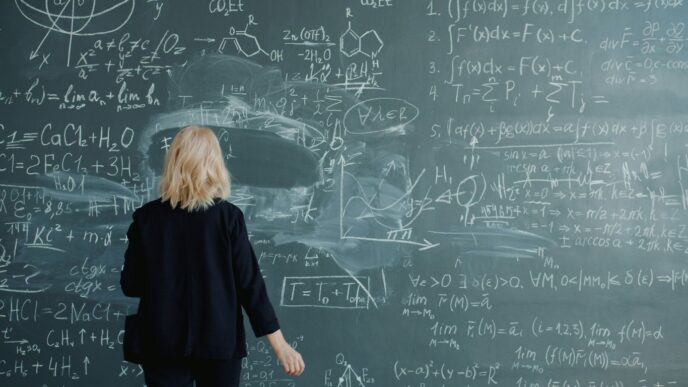 Woman looking at a blackboard with complex math equations.