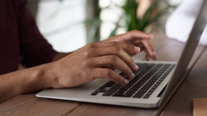 man typing on his laptop