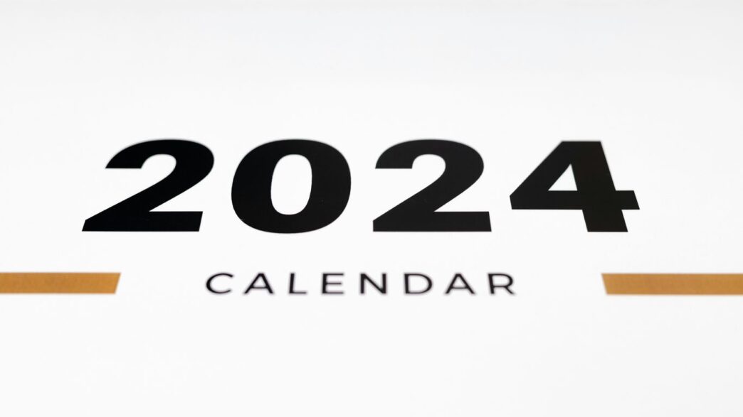 a white wall with a black and orange calendar on it