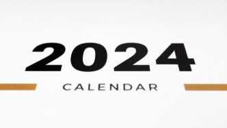 a white wall with a black and orange calendar on it