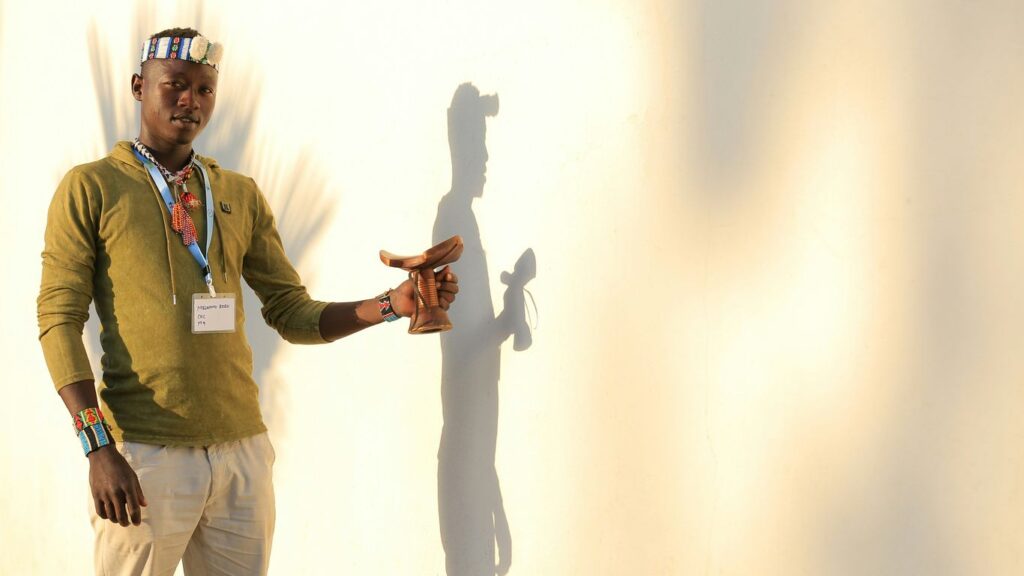 man in green button up shirt and white pants