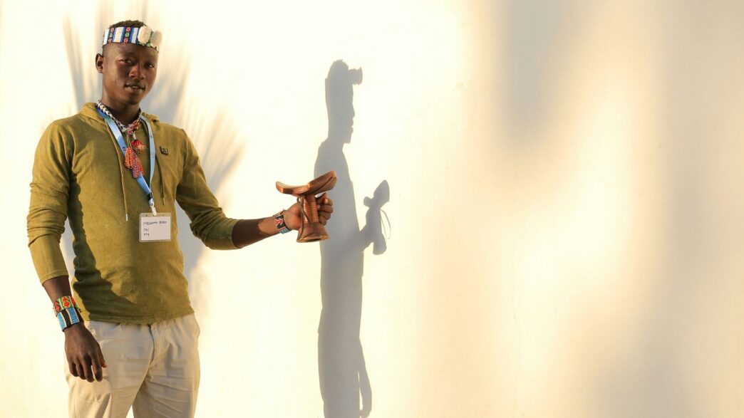 man in green button up shirt and white pants