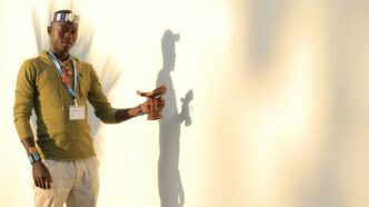 man in green button up shirt and white pants