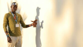 man in green button up shirt and white pants