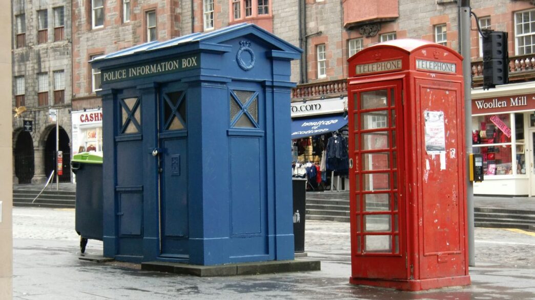 red telephone booth near brown building during daytime