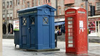 red telephone booth near brown building during daytime