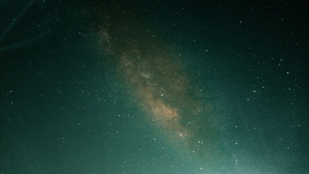 a person standing on a hill under a night sky