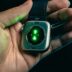 Hand holding smartwatch with glowing green sensor