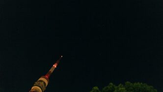 A very tall tower with a clock on it's side