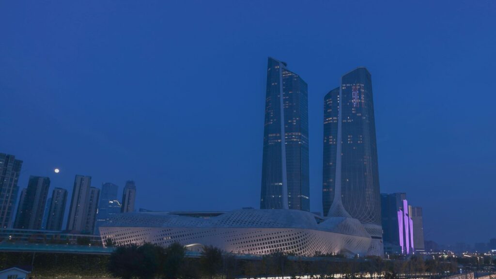 a city skyline at night with tall buildings in the background